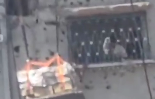 Thumbnail preview image for the video titled: Women reach out to airdropped aid stuck at their window